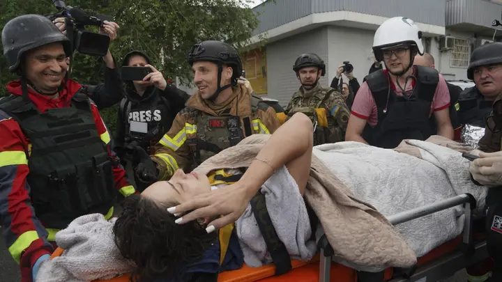Rescuers work at a damaged apartment building after a strike in Ukraine
